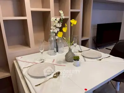 Elegant dining setup in modern living room with stylish shelving and TV unit.