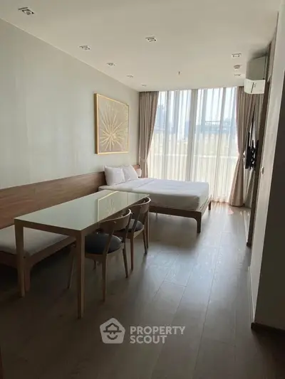 Modern studio apartment with large window and stylish decor