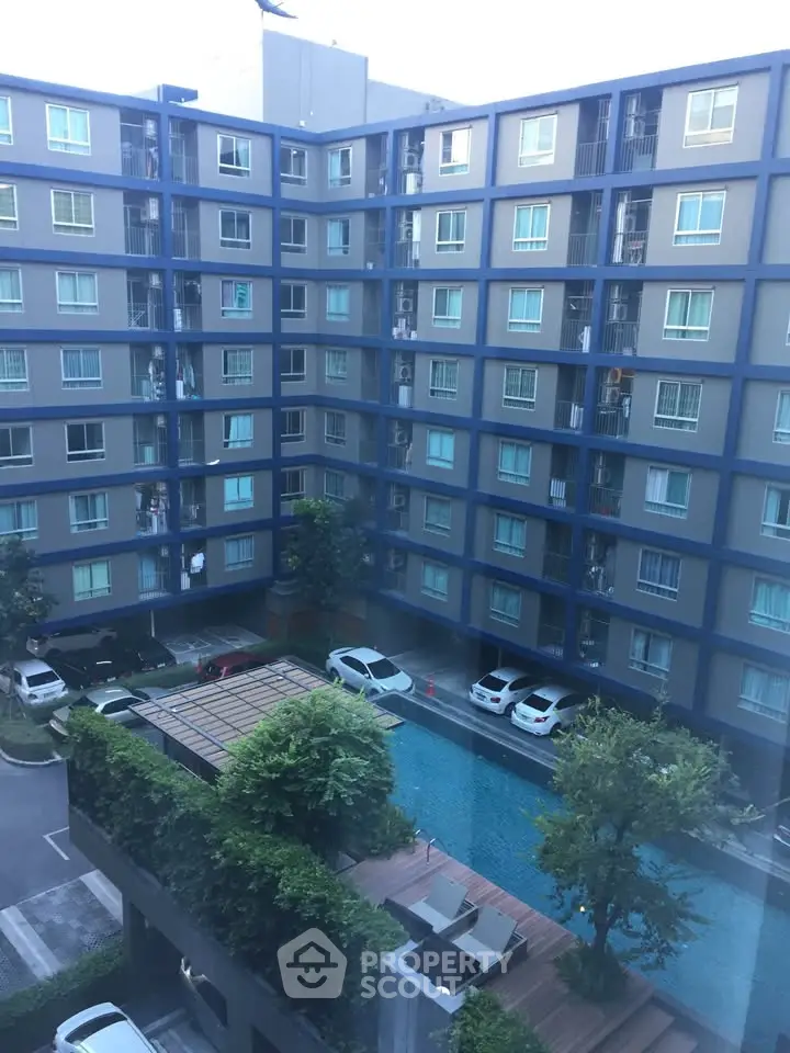 Modern apartment building with pool view and parking area, ideal for urban living.