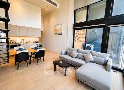 Modern open-plan living room with stylish kitchen and large windows