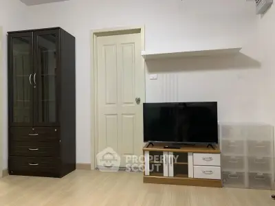 Modern living room with sleek TV stand, wardrobe, and minimalist decor