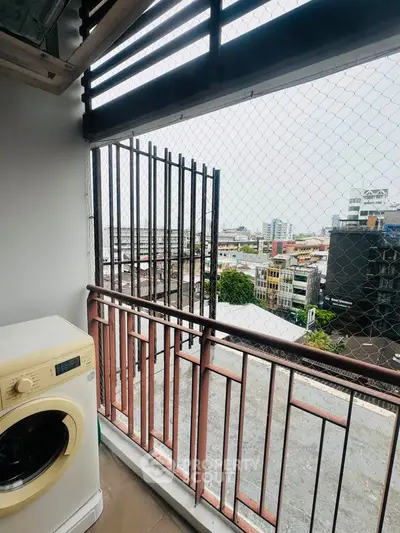 Urban balcony with washing machine and city view, perfect for modern living.