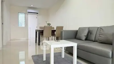 Modern living room with sleek furniture and dining area in open layout apartment.