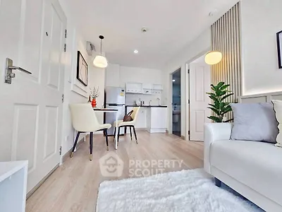 Bright and modern living room with open kitchen layout and stylish decor.