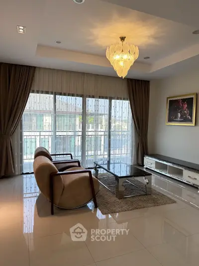 Elegant living room with modern furniture and large windows offering natural light.