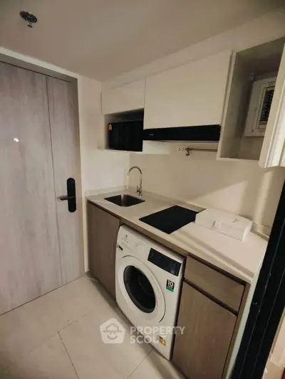 Compact modern kitchen with washing machine and sleek cabinetry