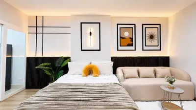 Modern bedroom with stylish decor, cozy bed, and elegant sofa in a chic apartment.