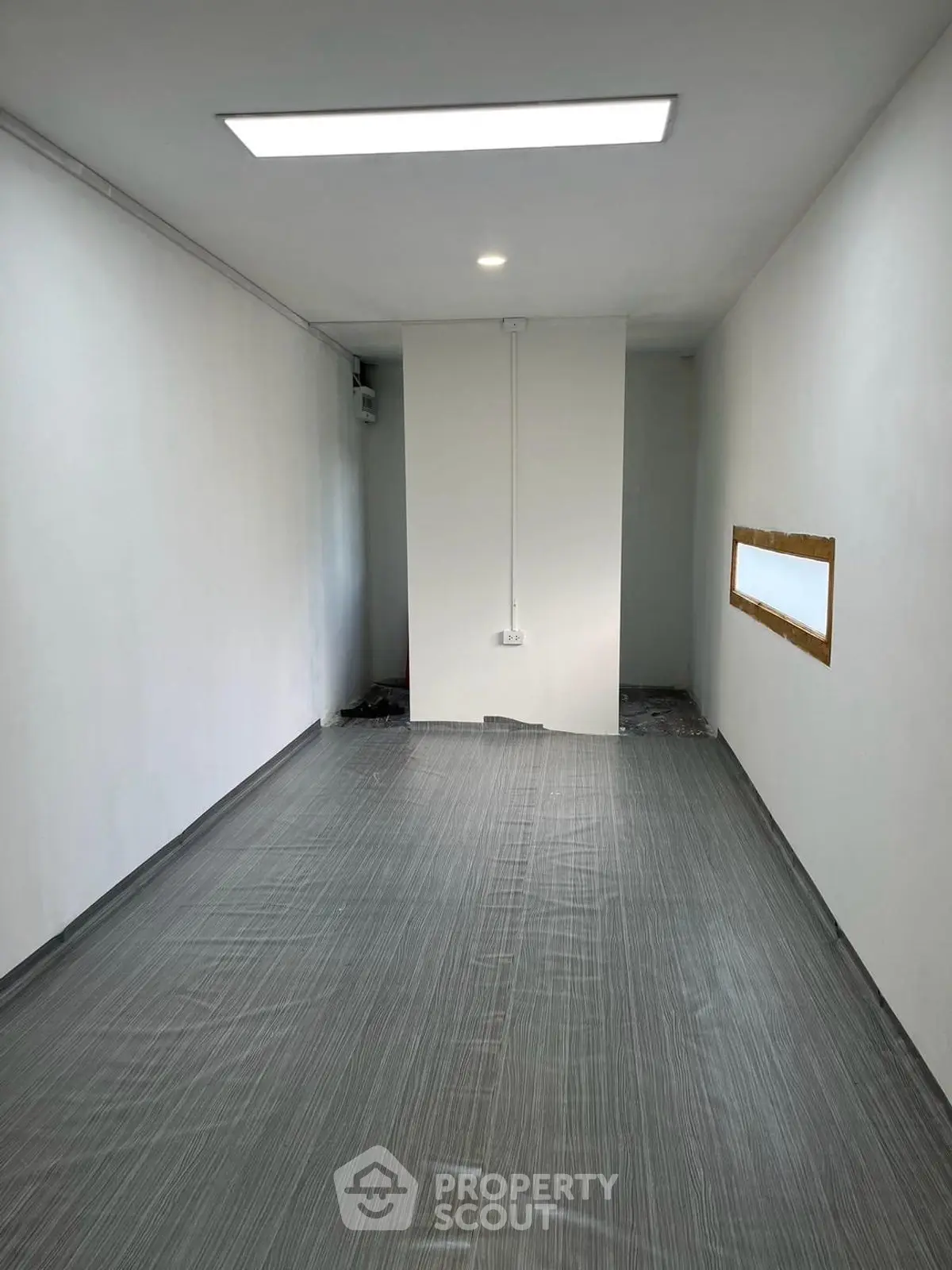 Minimalist empty room with modern flooring and bright lighting, perfect for customization.