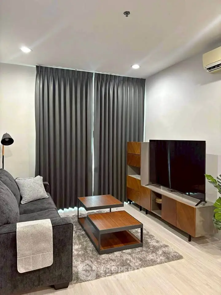 Modern living room with sleek furniture and large TV, perfect for relaxation and entertainment.