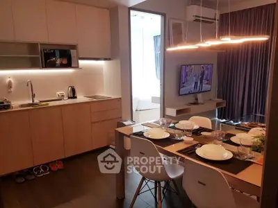 Modern open-layout kitchen and dining area with stylish lighting and cozy ambiance.