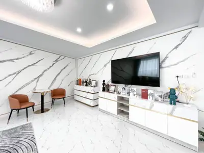 Luxurious modern living room with marble walls and floor, featuring a large TV and elegant furniture.