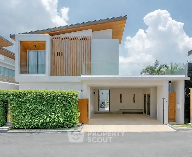 Modern luxury home with sleek architecture and spacious driveway, featuring a stylish facade and lush greenery.