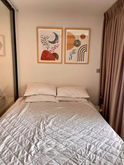 Cozy bedroom with modern decor and natural light, perfect for relaxation.