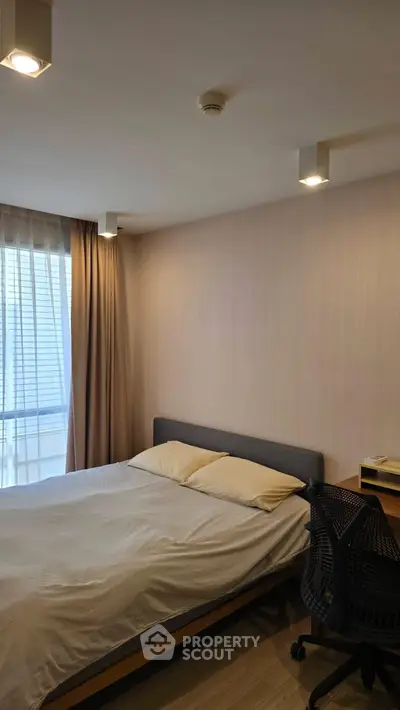 Modern bedroom with cozy bed and work desk, perfect for urban living.