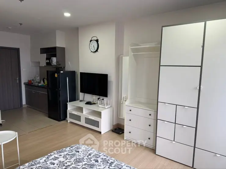 Modern studio apartment with sleek kitchen and ample storage space