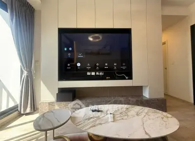 Modern living room with large TV and elegant marble coffee tables