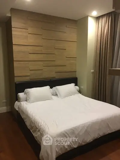 Modern bedroom with stylish wood panel accent wall and cozy lighting