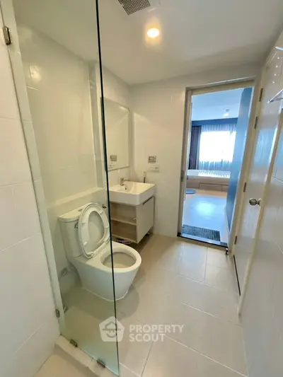 Modern bathroom with glass shower and sleek fixtures in a contemporary apartment.