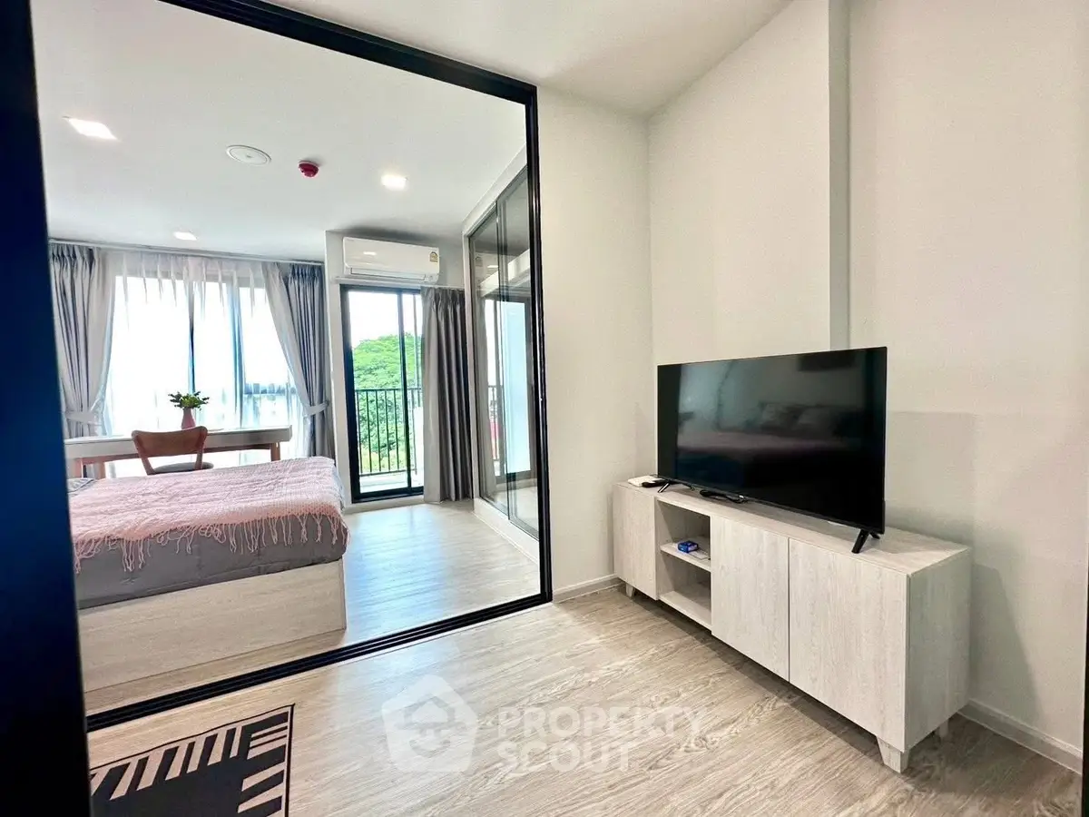 Modern apartment with open layout, featuring a cozy living area and bedroom with balcony view.