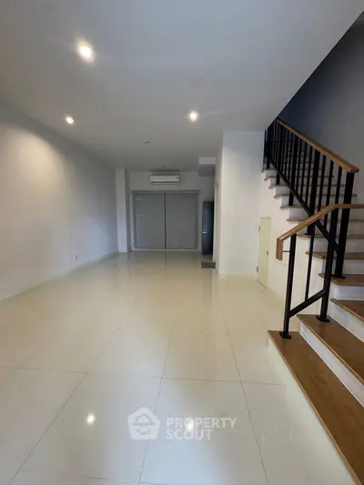 Spacious modern living room with sleek staircase and air conditioning