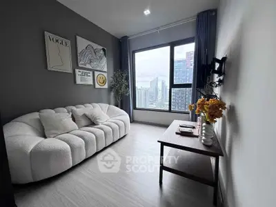 Modern living room with stylish decor and city view, featuring a cozy sofa and large window.