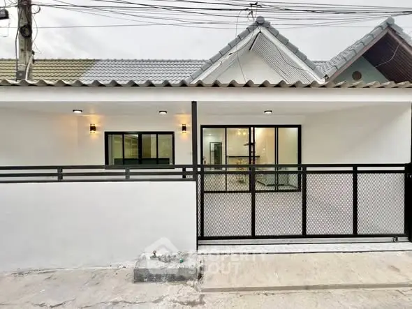Charming single-story home with modern facade and secure gated entrance.
