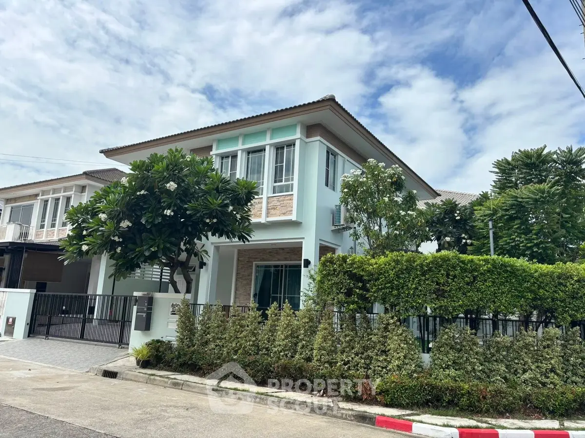 Charming two-story house with lush greenery and modern design in a serene neighborhood.