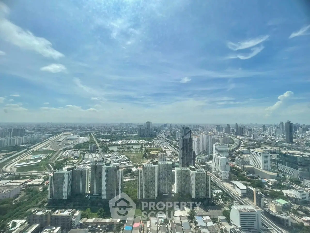 Stunning panoramic cityscape view from a high-rise building, showcasing urban skyline and clear blue skies.
