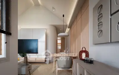 Modern living room with stylish decor and natural light, featuring a sleek TV setup and elegant dining area.