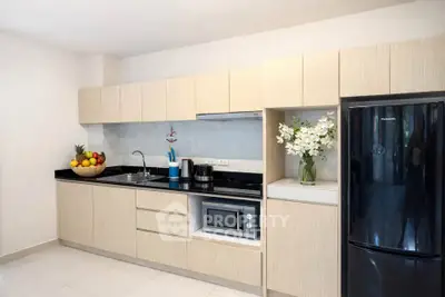 Modern kitchen with sleek cabinetry and black appliances in a stylish apartment.