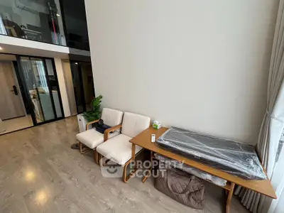 Modern living room with high ceiling and stylish furniture in a contemporary apartment.