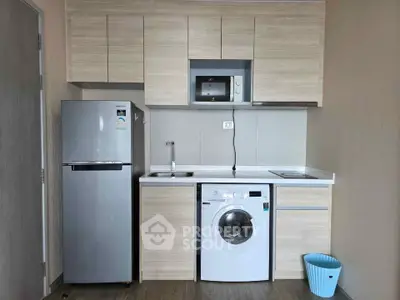 Modern compact kitchen with washing machine and microwave in stylish apartment