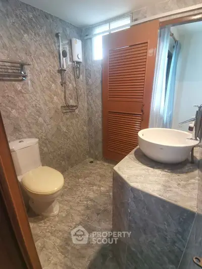 Modern bathroom with marble tiles and sleek fixtures in a stylish apartment.