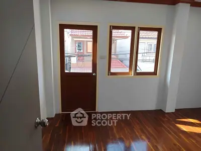 Bright room with wooden floor and balcony view, perfect for cozy living.