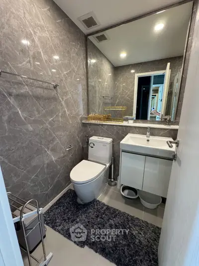 Modern bathroom with sleek gray marble walls and stylish fixtures.