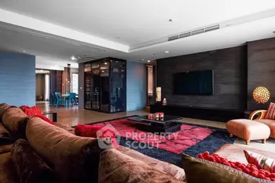 Luxurious and spacious living room with modern decor and large TV, perfect for entertaining.