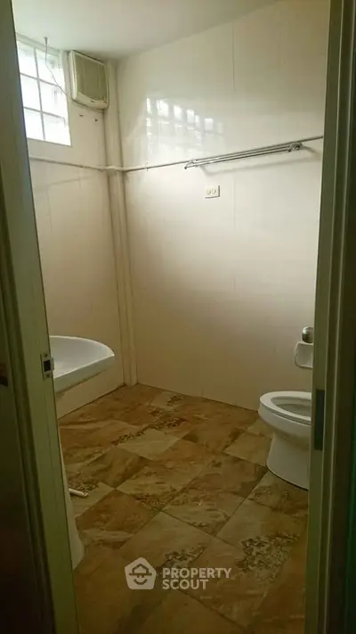 Spacious bathroom with tiled floor and natural light