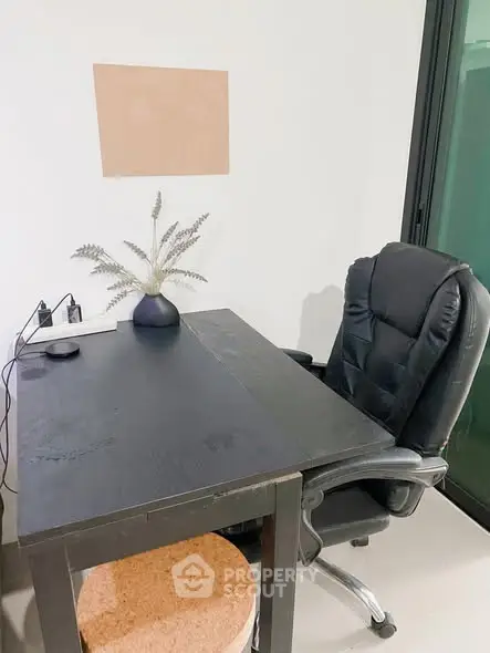 Modern study area with sleek black desk and ergonomic chair, perfect for productivity.