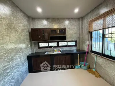 Modern kitchen with sleek cabinetry and large window, featuring a clean and minimalist design.