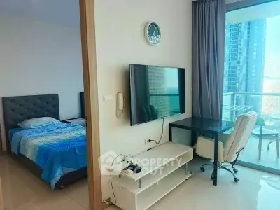 Modern apartment with bedroom, living area, and balcony with stunning sea view.