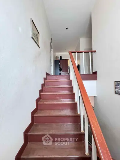 Spacious staircase with wooden railing in modern home interior