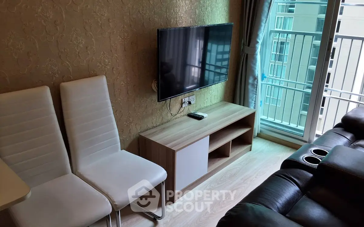 Modern living room with wall-mounted TV and balcony view in stylish apartment.