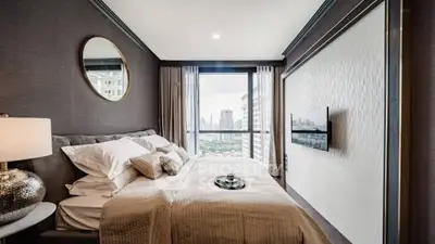 Luxurious bedroom with city view, modern decor, and elegant furnishings.