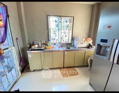 Charming kitchen with modern fridge and ample counter space in cozy home.