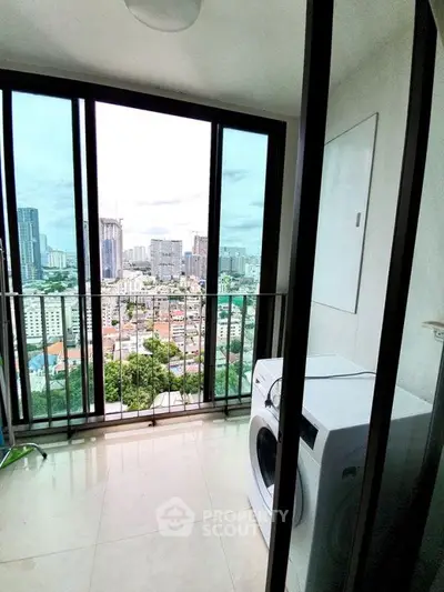 High-rise apartment balcony with city skyline view and washing machine.