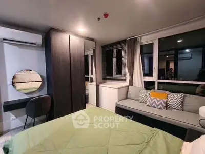 Modern bedroom with stylish decor, large window, and cozy seating area.