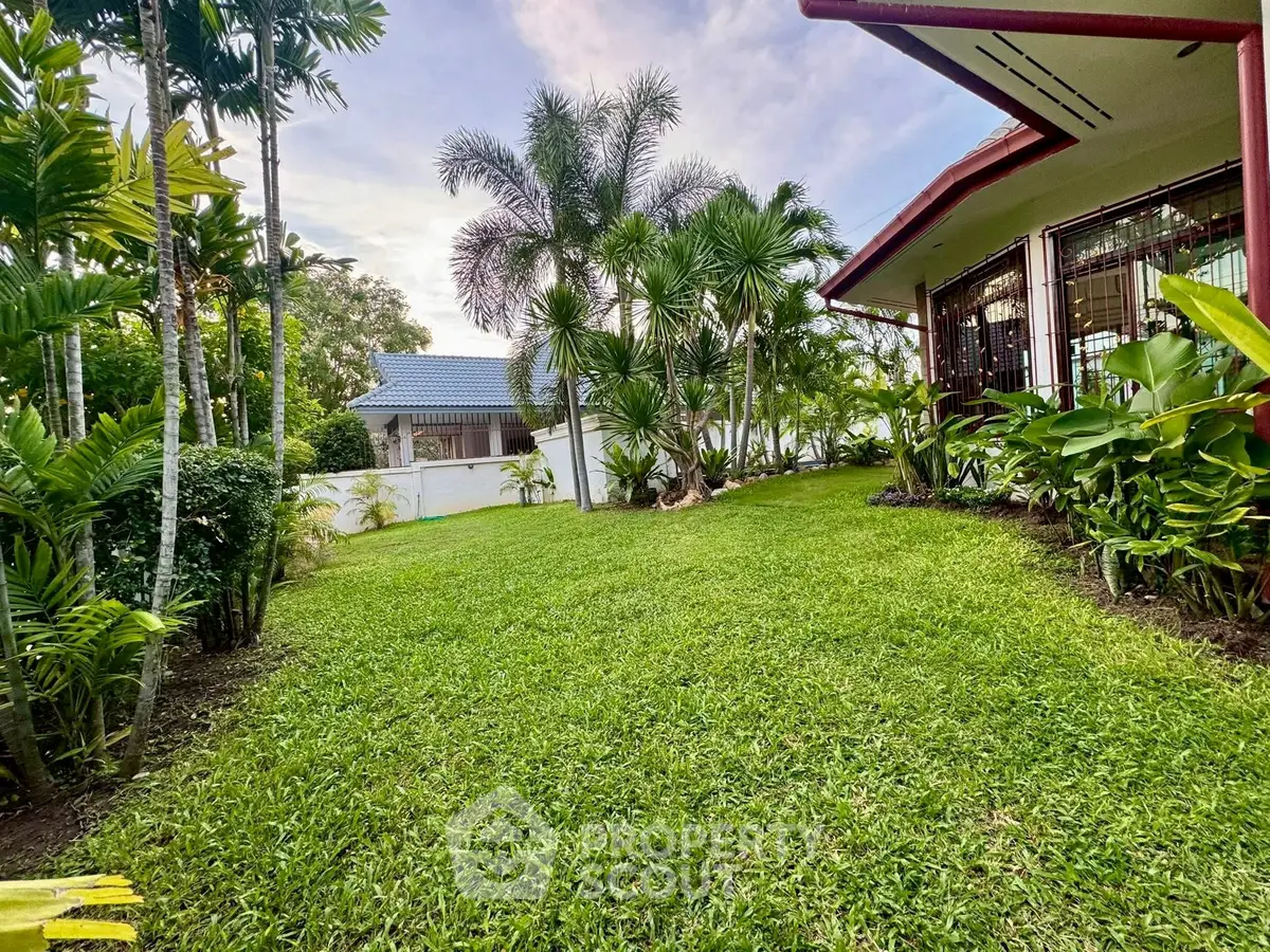 Lush garden with tropical plants and a charming house exterior