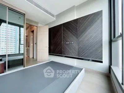 Modern bedroom with sleek design and large windows in a high-rise apartment.