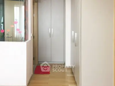 Modern hallway with sleek built-in storage and wooden flooring in a contemporary apartment.