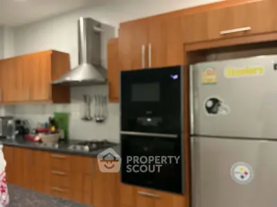 Modern kitchen with wooden cabinets, stainless steel appliances, and sleek countertops.